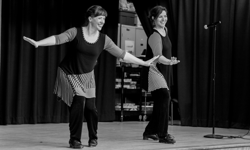 Marsha and Augie of Footworks dancing with tap shoes on stage at Maryland City Elementary