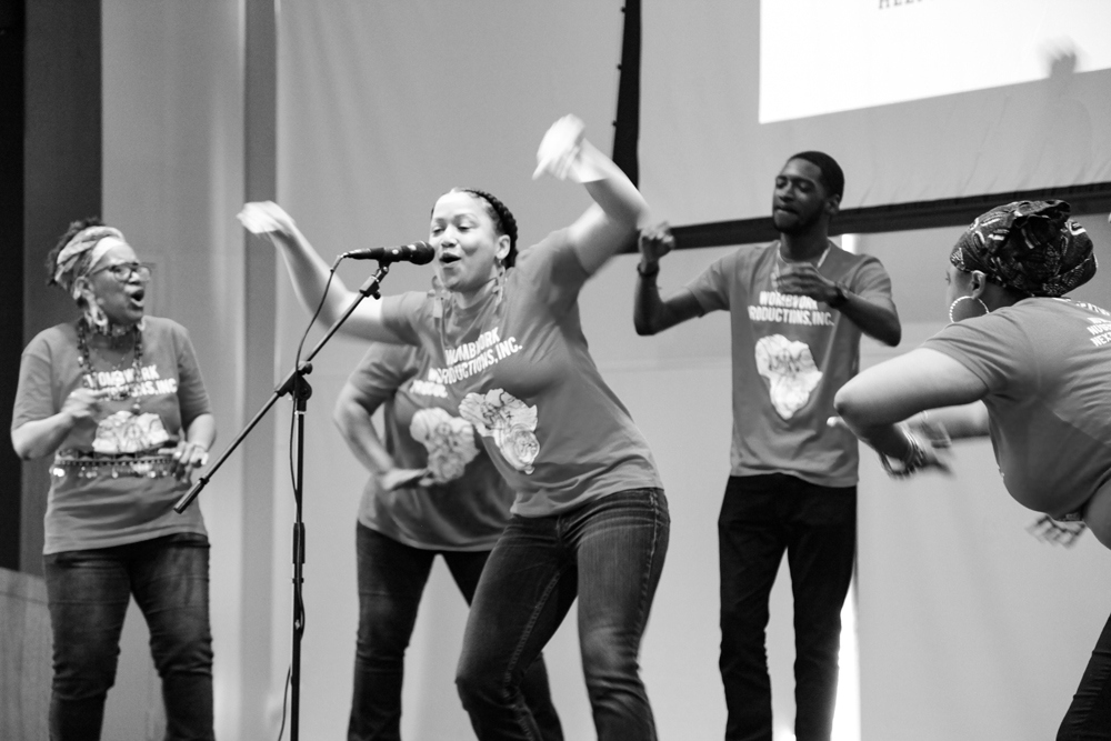 Members of Wombwork Productions ensemble takes turns at the mic onstage.