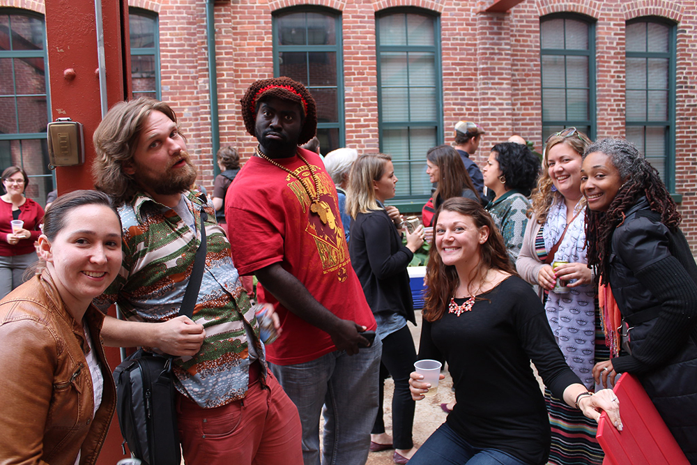 Artists and Staff tasing for a group photo in the courtyard of a renovated industrial building